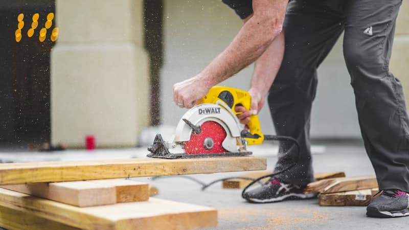 Joiner cutting timber with a circular saw on site